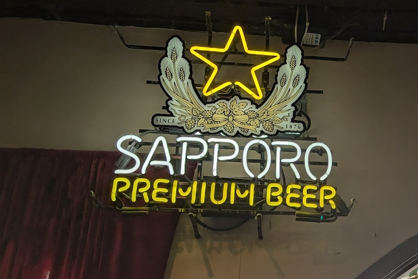 A fluorescent sign in a Melbourne pub promotes 'Sapporo premium beer'