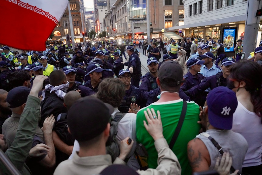 An image of police approaching a crowd of protesters.
