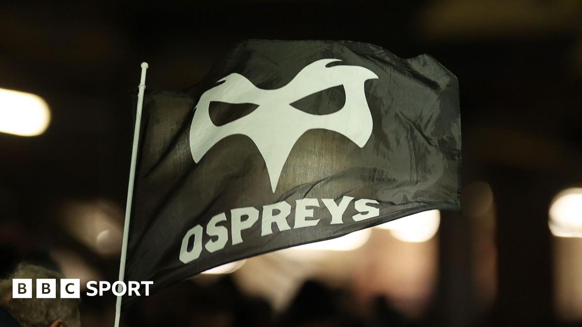 An Ospeys flag flutters in the breeze at a game