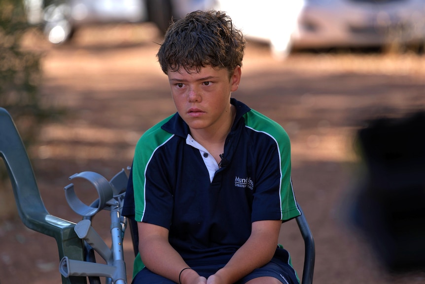 A boy sits in a chair listening intently