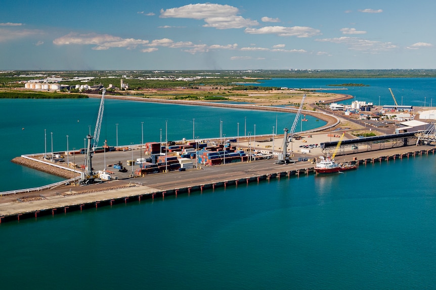 An aerial view of a wharf part of the Darwin Port, with the city of Darwin in the distance.