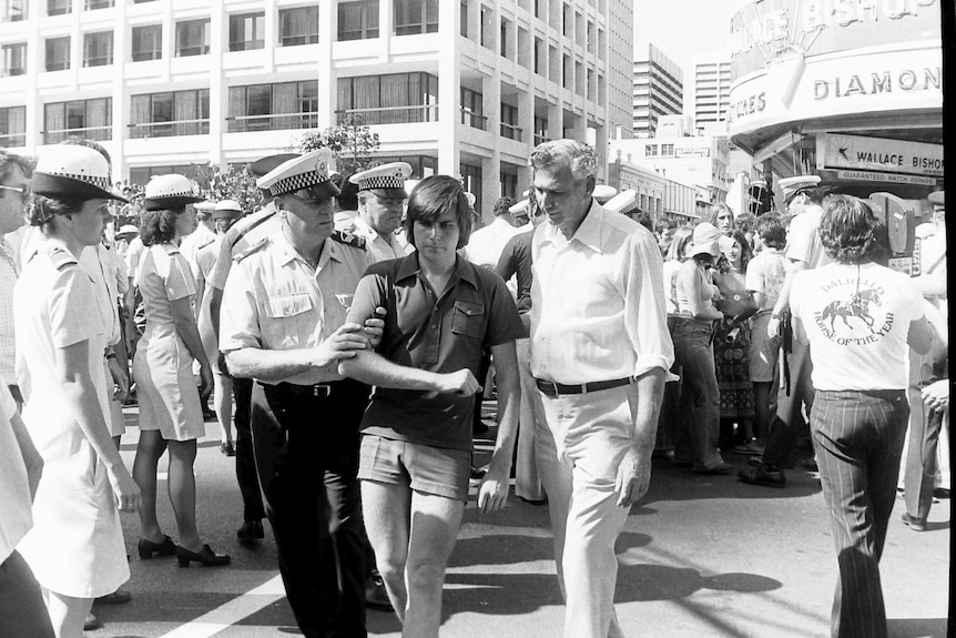 A young protester is arrested in black and white