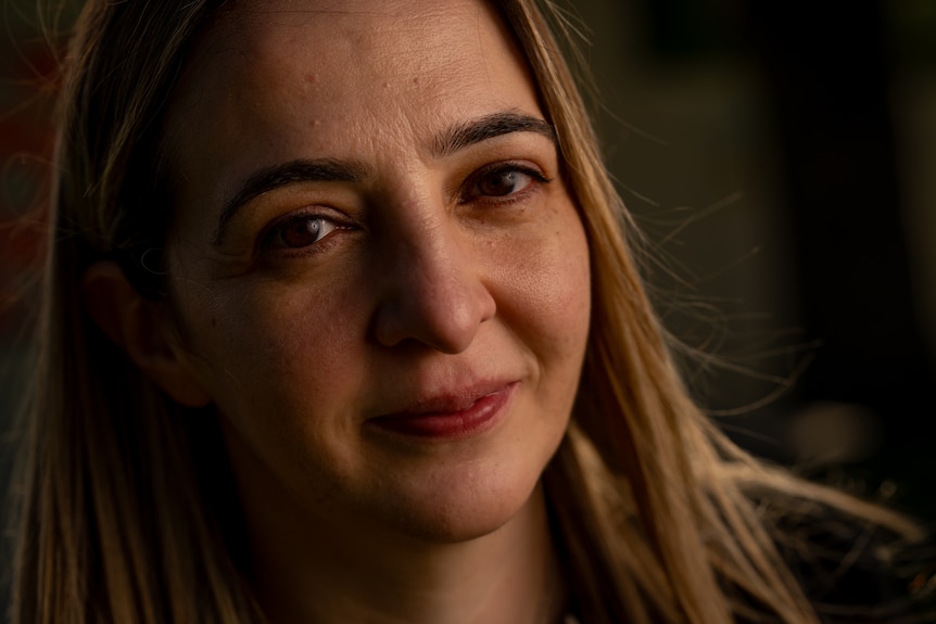 woman looks away from the camera wearing a black jumper