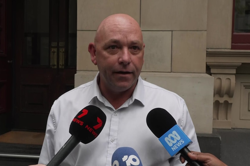 Richard talks to several microphones being held by reporters, channel 7, ABC  logos in view.