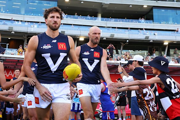 Marcus Bontempelli and Max Gawn of Victoria lead the team onto the ground.