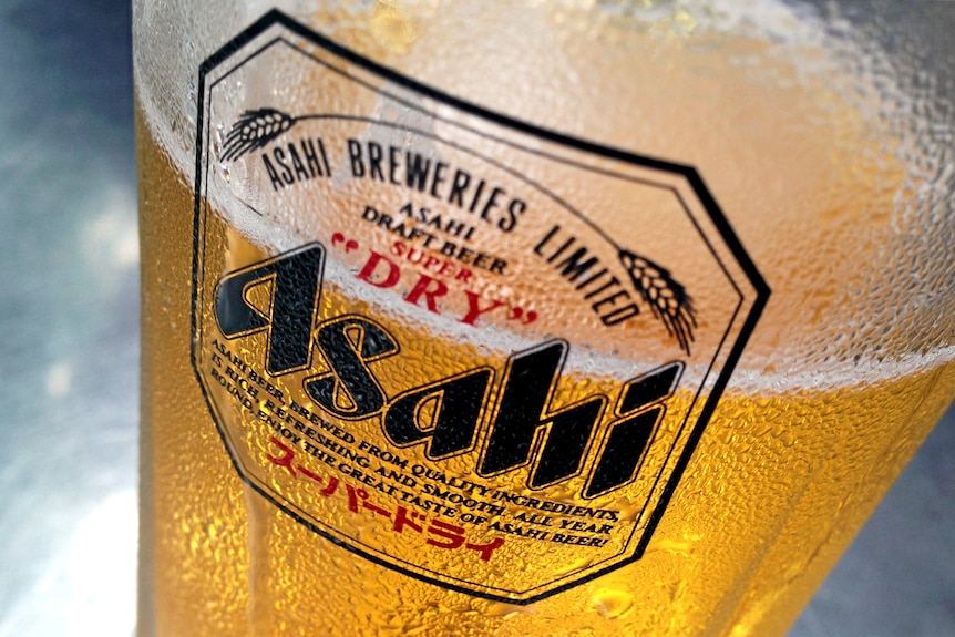 Condensation collects on a glass of Asahi beer