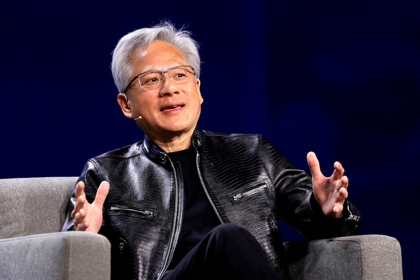 Jensen Huang gestures while speaking and sitting on a couch
