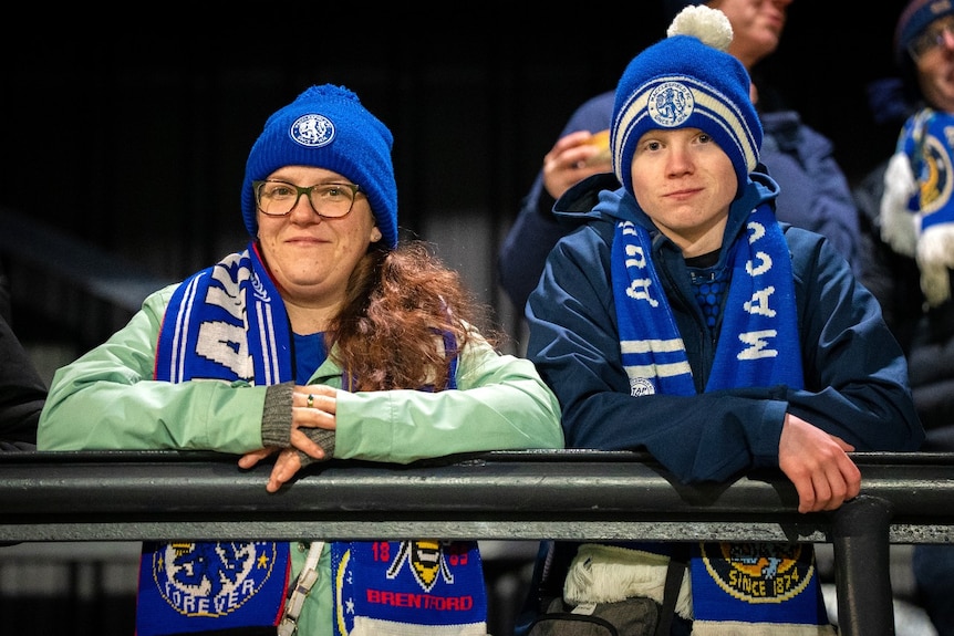 A woman and a young child smiling and looking at the camera.
