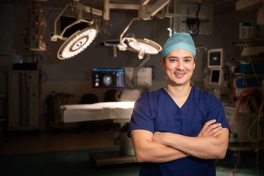 Man in scrubs in front of an operating theatre