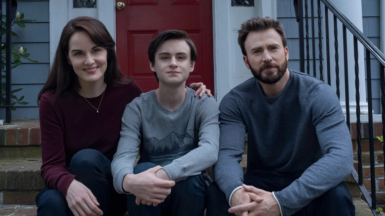 Michelle Dockery, Jaeden Martell, and Chris Evans as the Barber family, sitting on their steps in Defending Jacob
