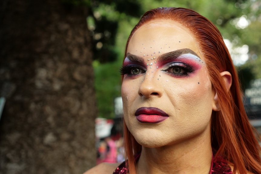 A close up of a person's face with make up and red hair