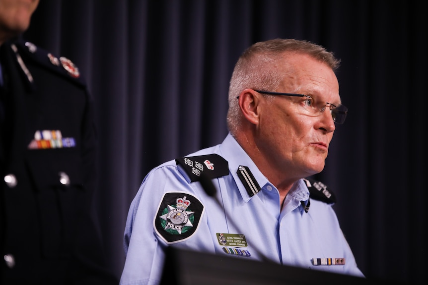 Peter Hatch speaks at a lectern in uniform. 