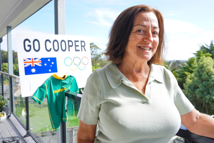 a woman leans against a railing 