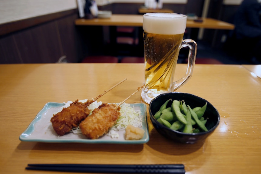 Deep fried skewers, green soybeans and a glass of beer at a restaurant in Japan