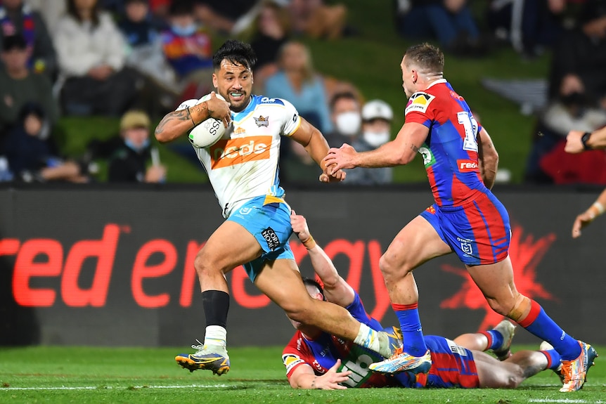 A man runs the ball during a rugby league match 