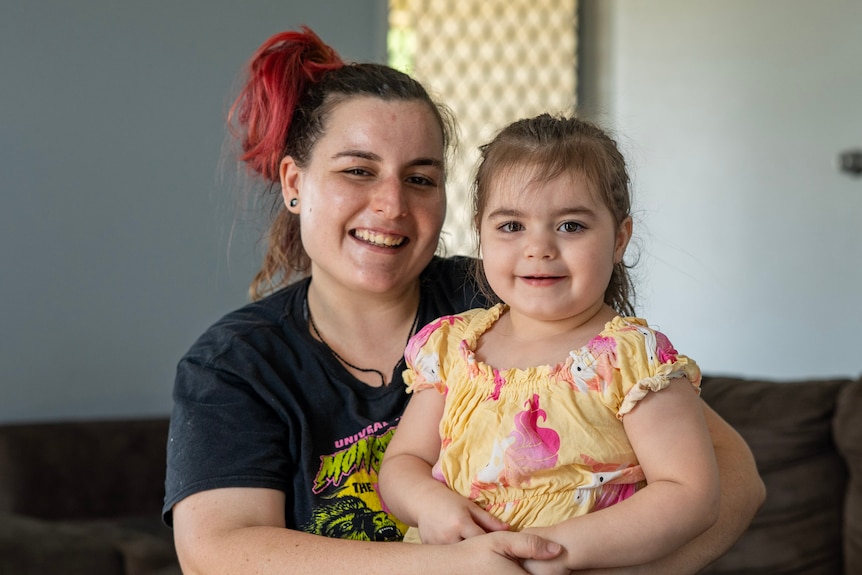 A woman sitting on a couch with a toddler in her lap.