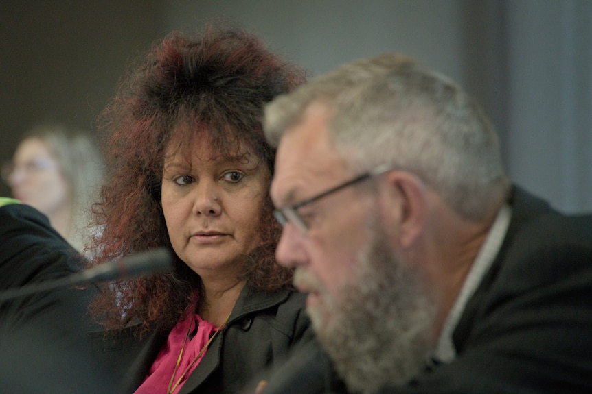 A close up of heads. Malarndirri McCarthy looks at Scott Wilson. She is in focus. 