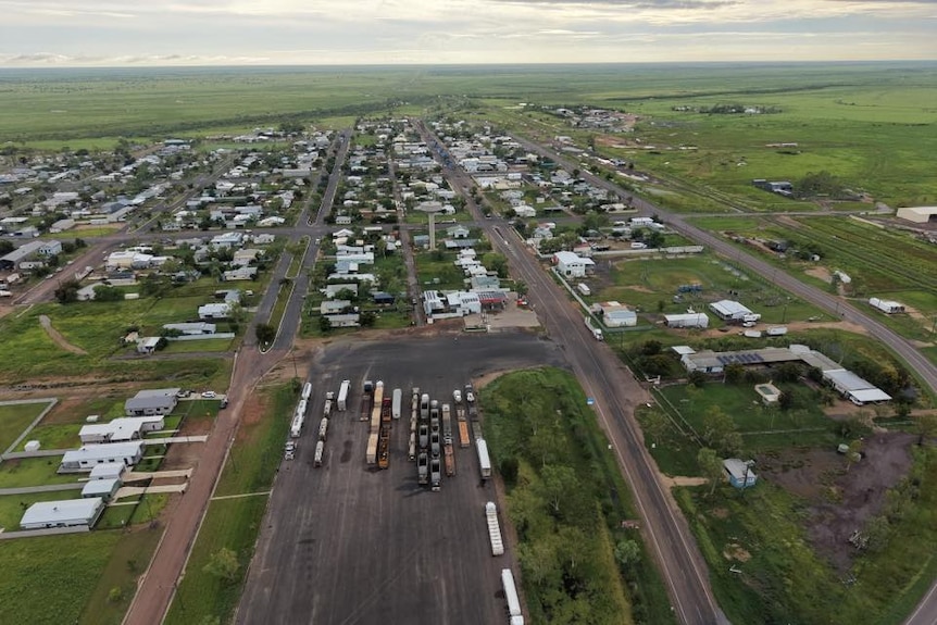 A picture from a plane looking down at trucks lined up waiting in Julia Creek for the road east to open up.