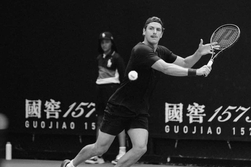 A tennis player holds a racket.