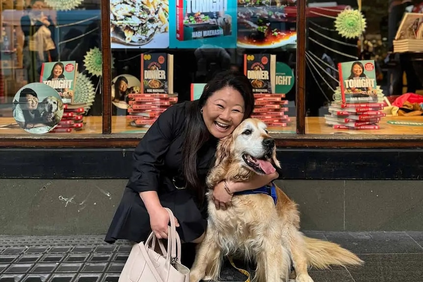 Nagi Maehashi poses with her golden retriever Dozer in front of a bookstore window.