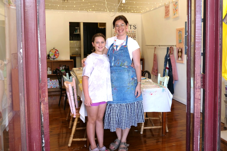 Deanna Reynolds standing with her daughter in the doorway of her new art studio. 
