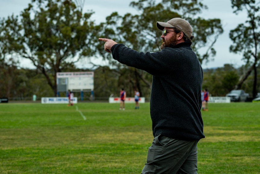 A man on the football field points.