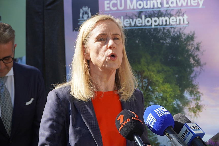 Simone is wearing a red top as she delivers a press conference