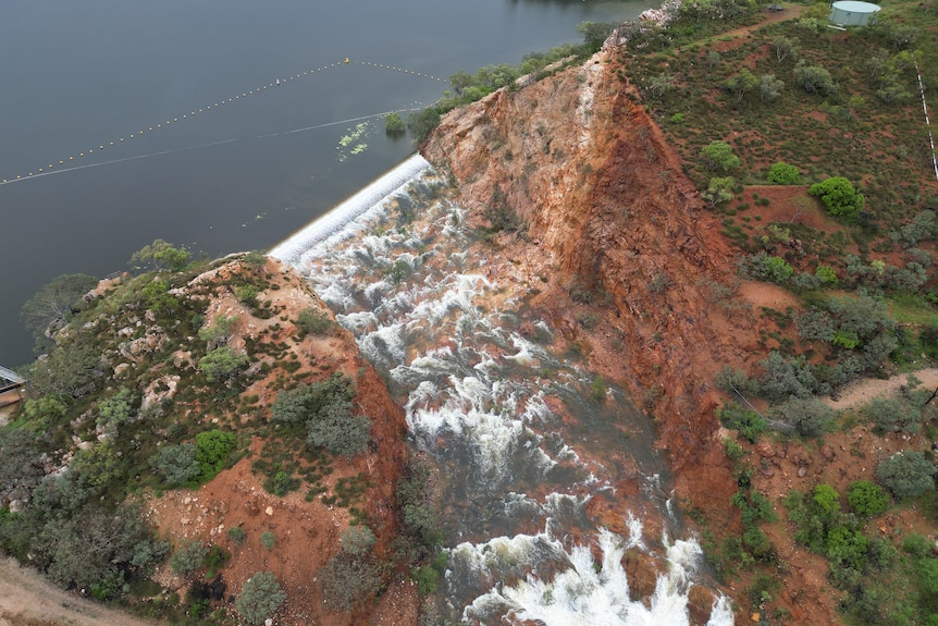 A birds eye view image or water spilling over a lake edge.