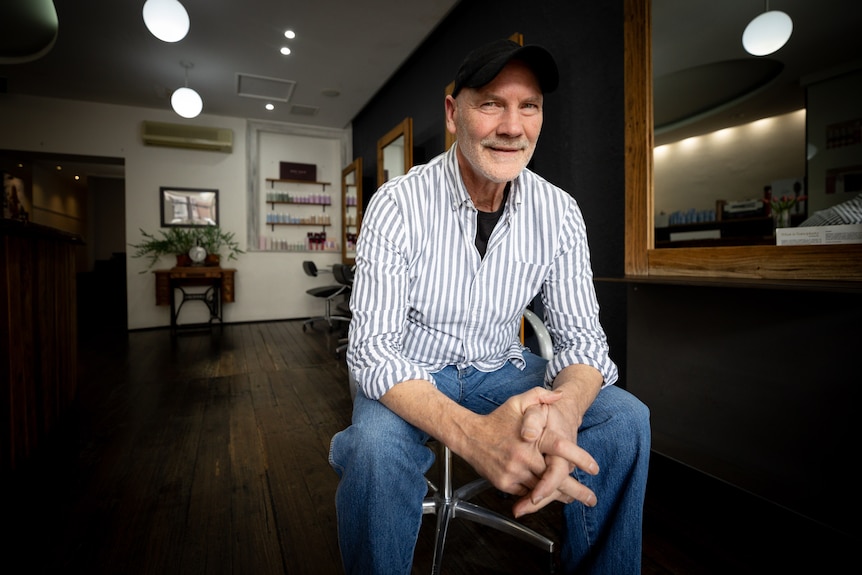 A man in a striped shirt and black hat.