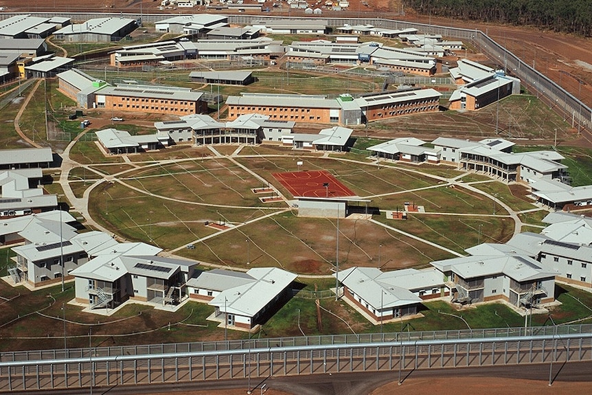 An overhead shot of prison buildings positioned around a circle centre with sports field in the middle.