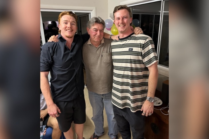 A proud Michael Mckay stands in the middle of his sons Adam and Brett, as the trio hugs.