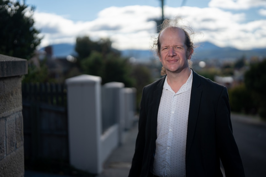 Man smiles for photo.