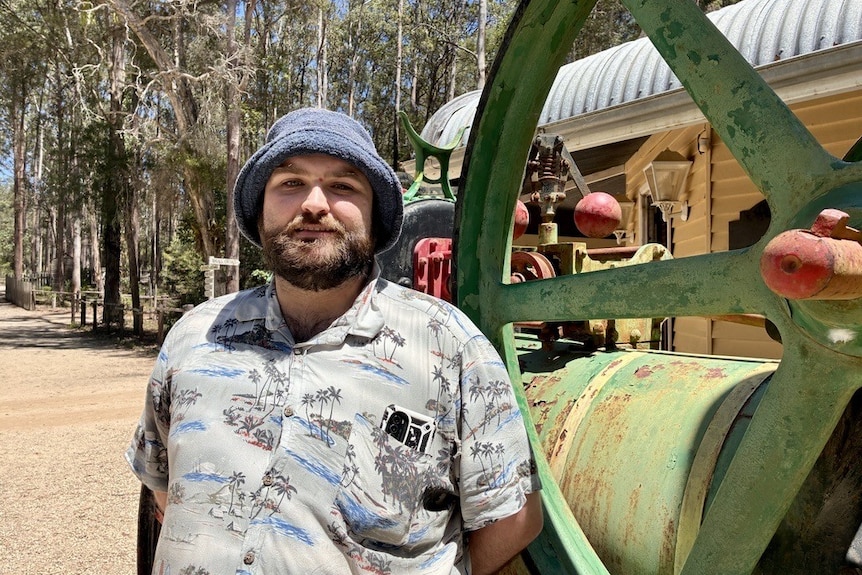 A man with a beard and bucket hat smiles slightly at the camera. 