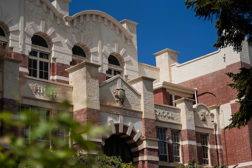 Old school building in white and brown sandstone.