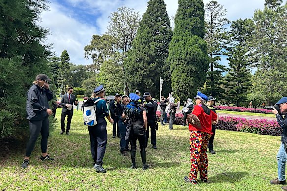 Victoria Police officers and anti-Herzog protesters outside Government House on Thursday.