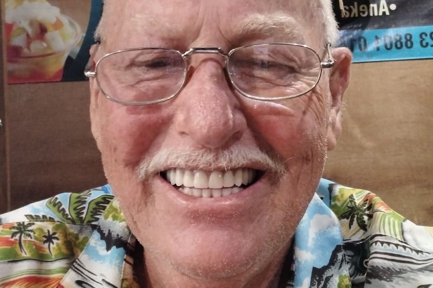 Man with colourful shirt, moustache and glasses