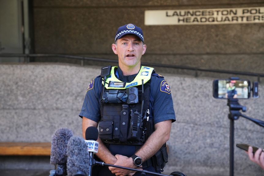 A police officer stands in front of a police station.