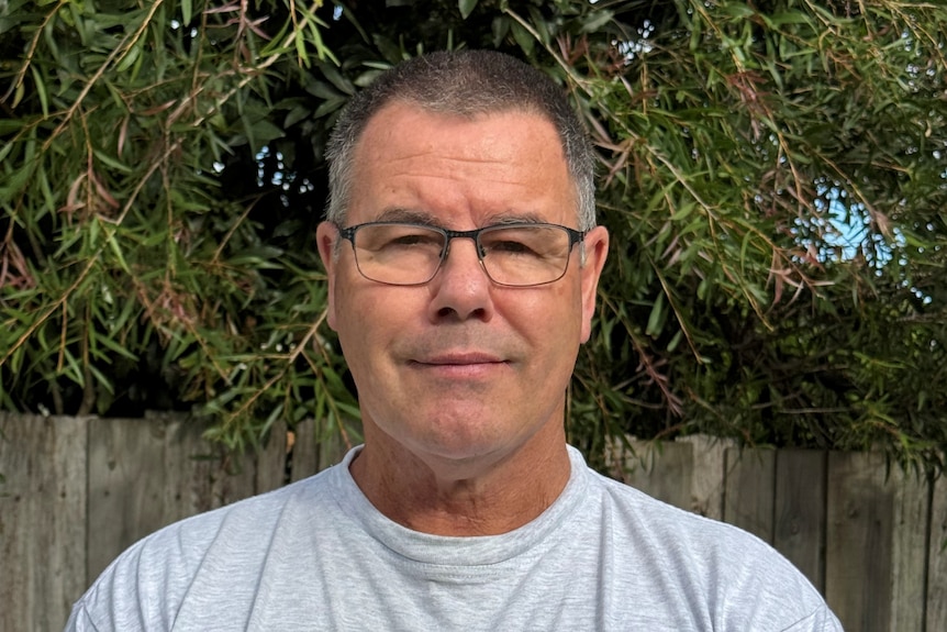 man with glasses and short hair looking at camera