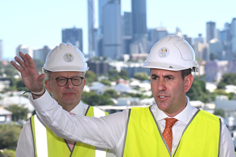 Two men in ties and hard hats in front of a Melbourne skyline: Anthony Albanese and Jim Chalmers