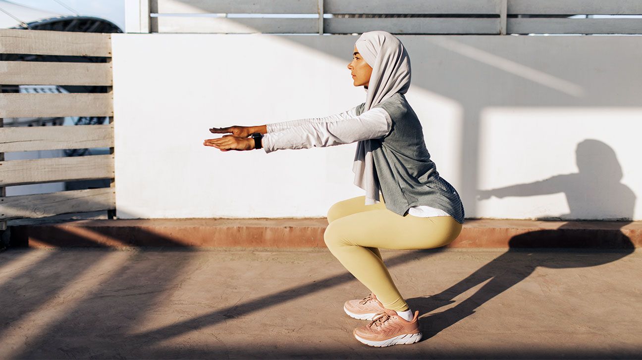 Female doing squats outside in the sunshine