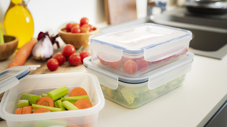 plastic food containers on a kitchen counter with food visible inside.