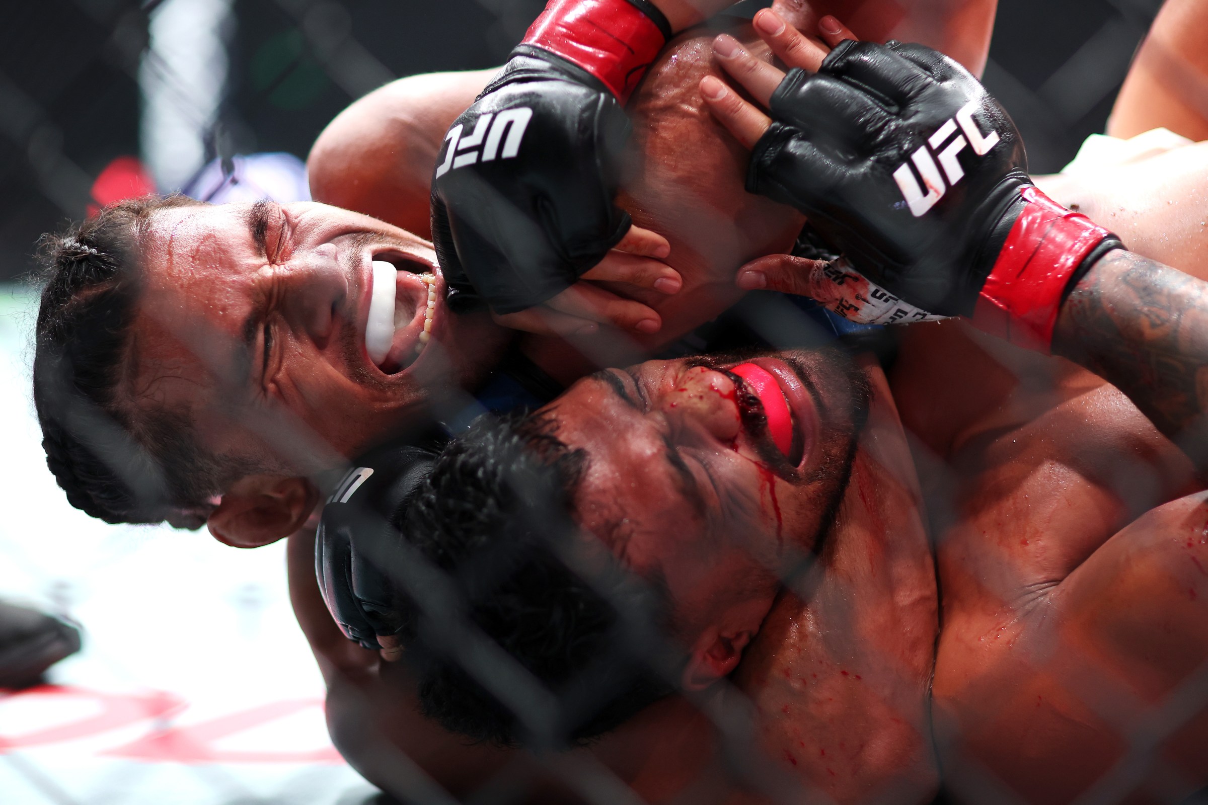 SYDNEY, AUSTRALIA - FEBRUARY 01: (L-R) Billy Elekana of the USA secures Junior Tafa of Australia choke hold to win in a light heavyweight fight during the UFC 325: Volkanovski v Lopes 2 at Qudos Bank Arena on February 01, 2026 in Sydney, Australia. (Photo by Mark Kolbe Photography/Getty Images)