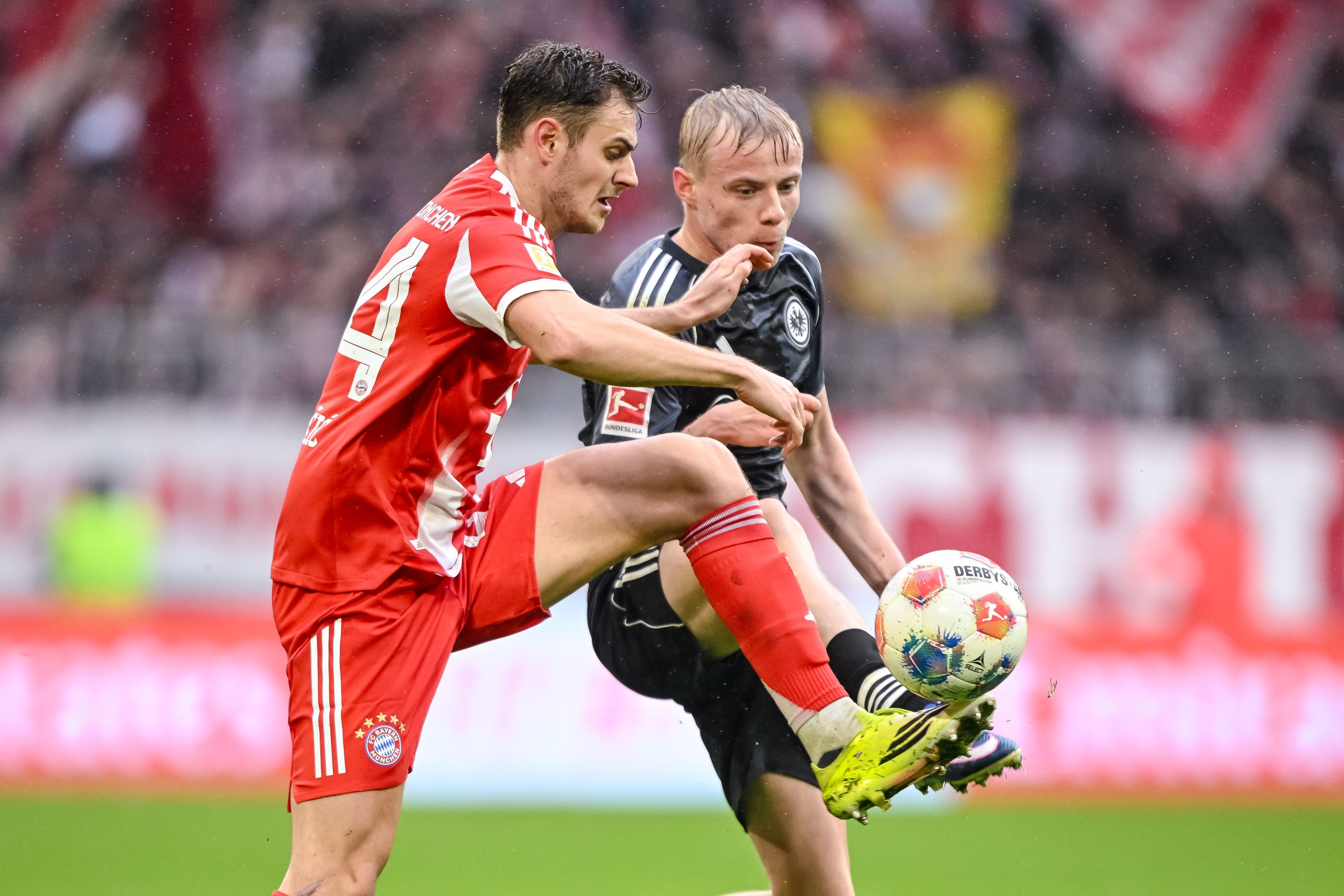 21 February 2026, Bavaria, Munich: Soccer: Bundesliga, Bayern Munich - Eintracht Frankfurt, Matchday 23, Allianz Arena. Josip Stanisic (l, Bayern Munich) in action against Oscar Höjlund (Eintracht Frankfurt). Photo: Harry Langer/dpa - IMPORTANT NOTE: In accordance with the regulations of the DFL German Football League and the DFB German Football Association, it is prohibited to utilize or have utilized photographs taken in the stadium and/or of the match in the form of sequential images and/or video-like photo series. (Photo by Harry Langer/picture alliance via Getty Images)