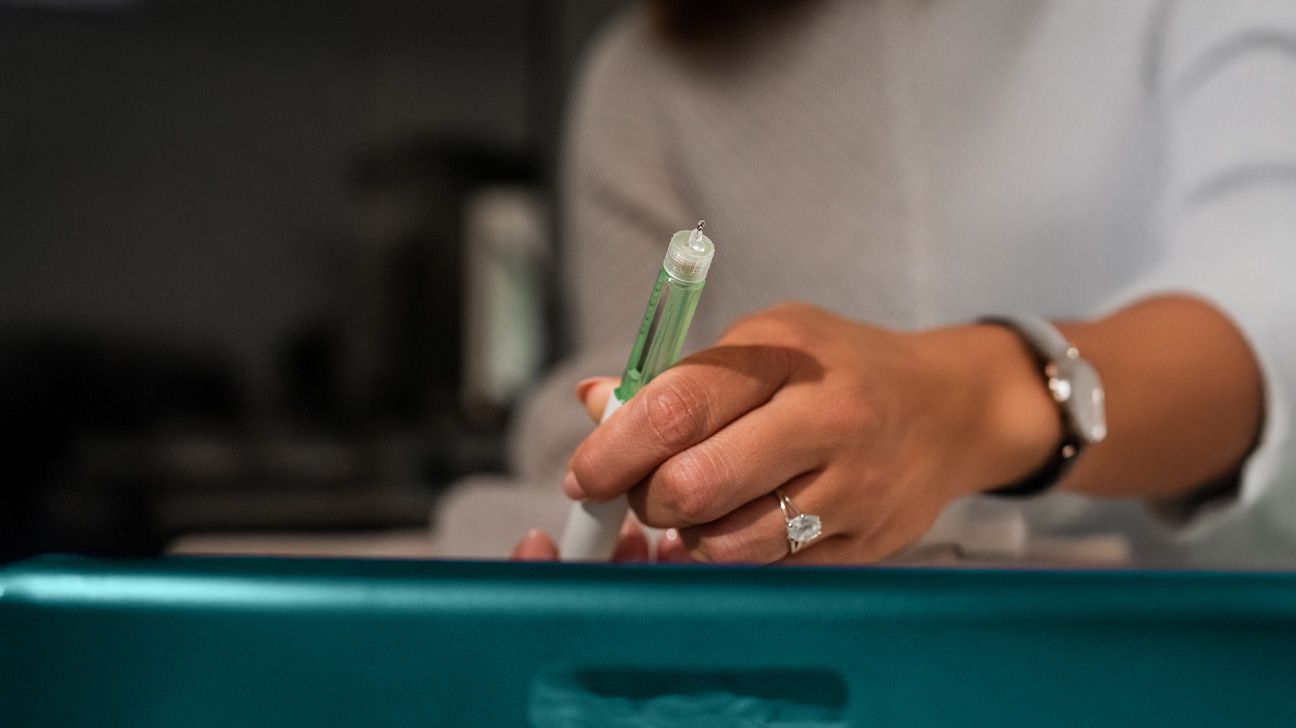 A person holding a GLP-1 injector pen.
