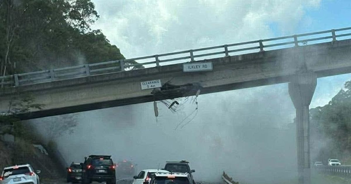 Major highway closed after truck carrying excavator hits overhead bridge