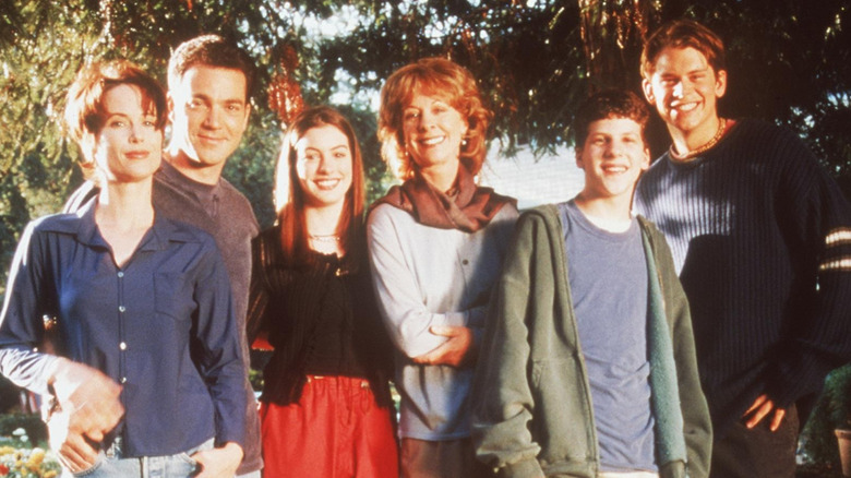 Group shot of the Green family and Elizabeth Parker against a background of trees