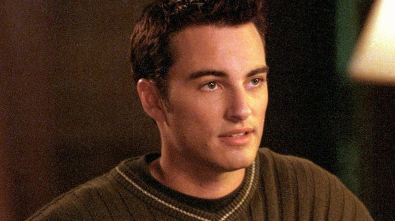 Jack (Kerr Smith) wears a brown ribbed sweater in a warmly lit room in Dawson's Creek