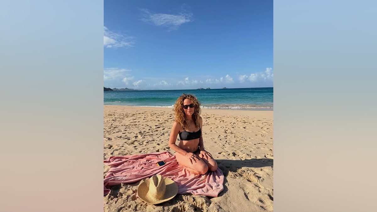 Jennifer Grey relaxes on the beach in a black one-piece swimsuit during a girls getaway.