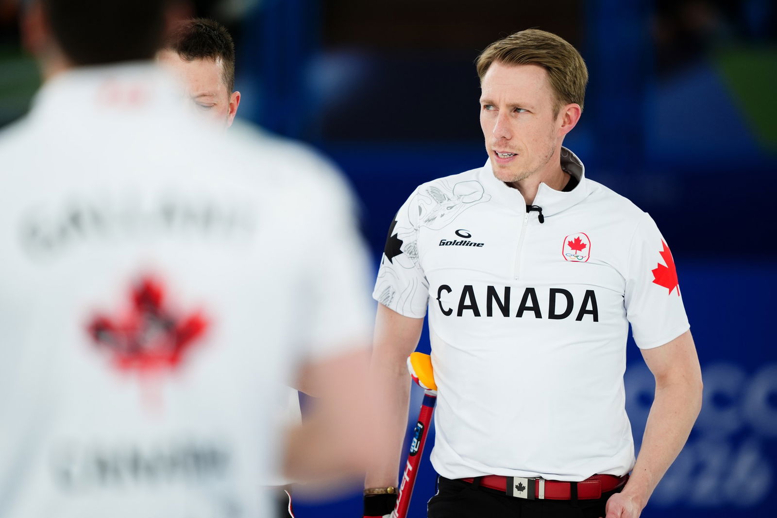 A man in a white shirt stands with a white shirt on