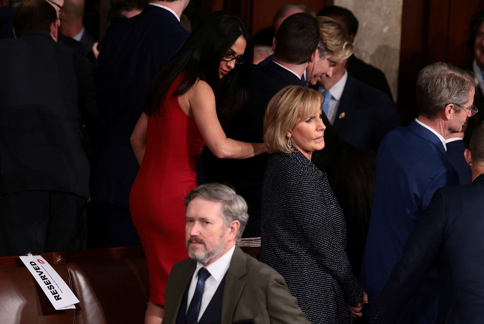 lauren boebert holds on to claudia tenney's shoulder while standing on a chair
